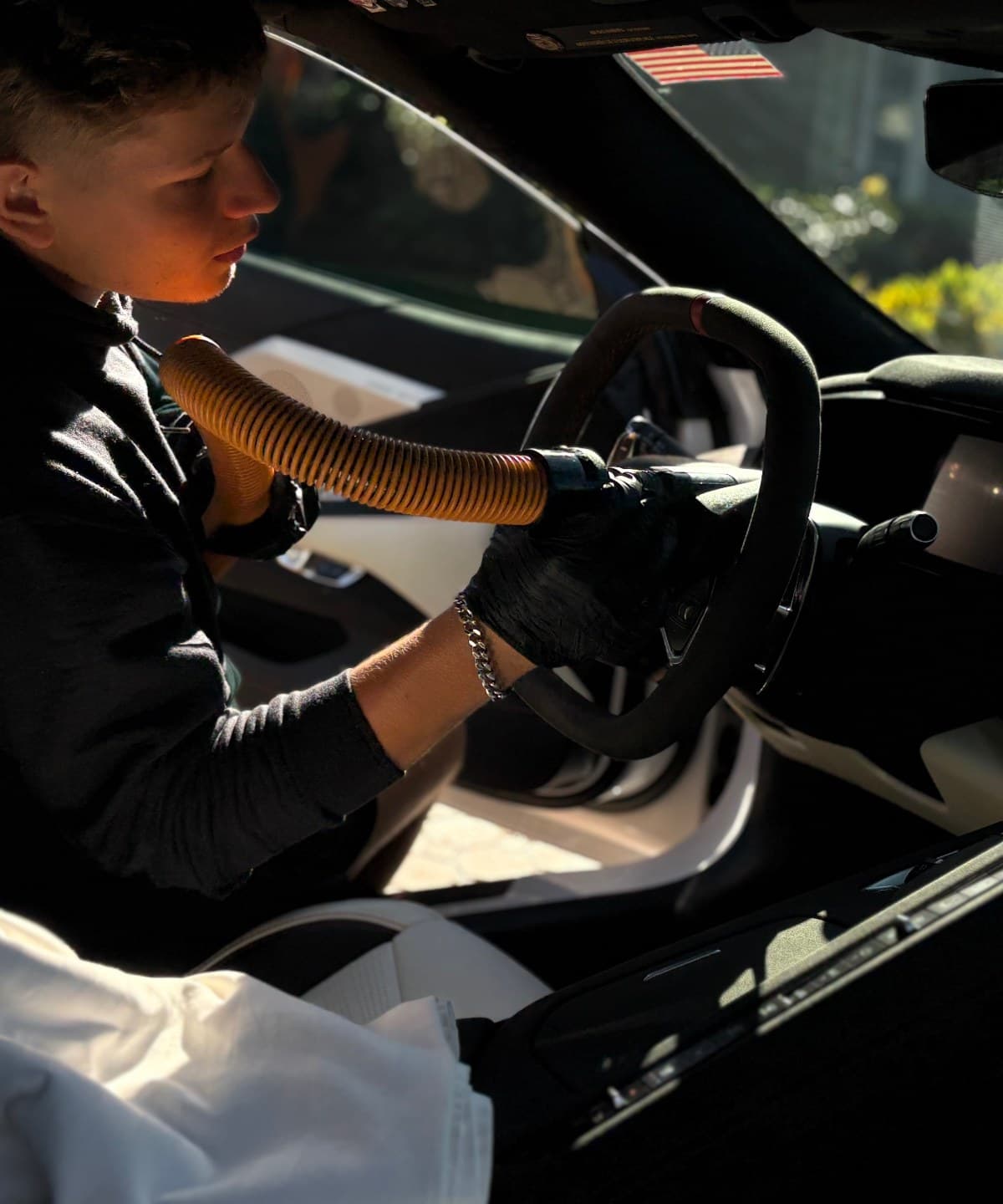 Detailer foam washing a black Lamborghini Urus in a Central Florida driveway